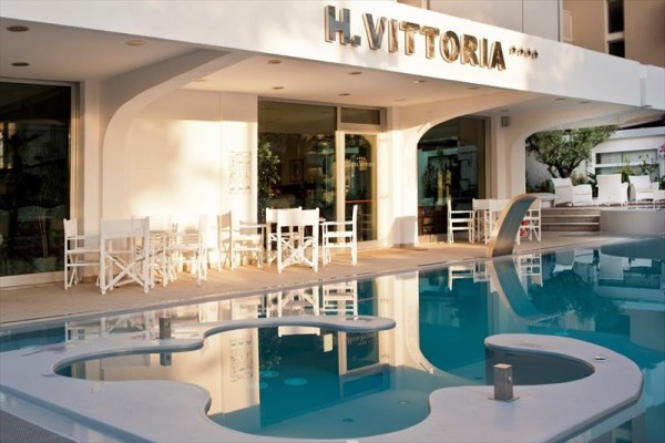 Wejście do hotelu o nazwie H. Vittoria i basen na pierwszym planie.
