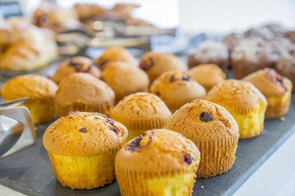 Różne rodzaje muffinek wystawione na tacy.