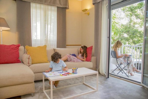 Troje dzieci odpoczywa i rysuje w salonie i na balkonie.