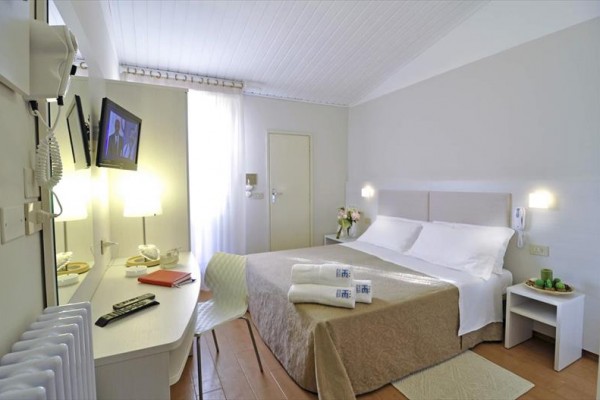 Nowoczesny pokój hotelowy z łóżkiem małżeńskim, telewizorem i stołem.