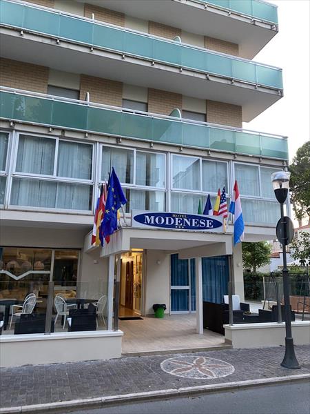Wejście do hotelu z kilkoma flagami nad nim.