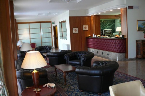 Elegancki hol hotelowy z skórzanymi fotelami i recepcją.