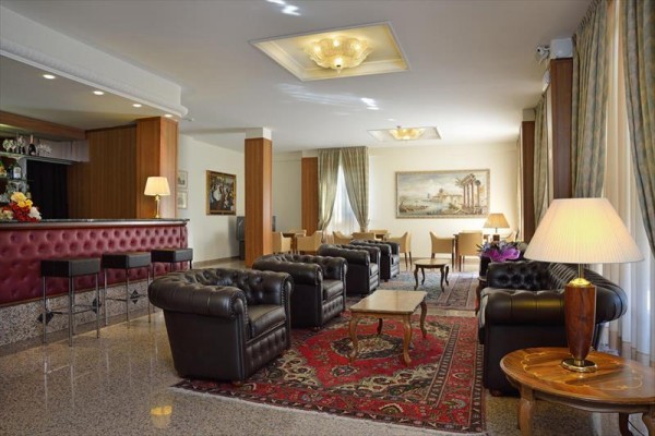 Eleganckie lobby hotelowe z skórzanymi sofami, dywanami i barem.
