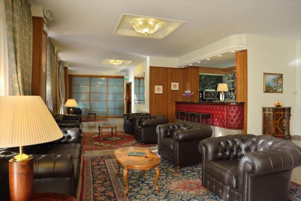 Eleganckie lobby hotelowe z skórzanymi sofami i barem.