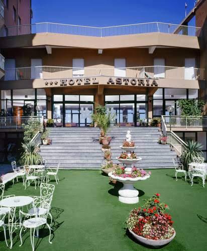Wejście do Hotelu Astoria z tarasem i ogrodem kwiatowym.
