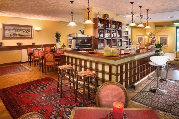 Wnętrze restauracji z drewnianym barem i czerwonymi dywanami.