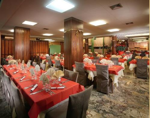 Luksusowa restauracja z czerwonymi obrusami i starannie nakrytymi stołami.