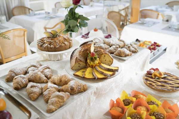 Różne rodzaje pieczywa i ciast na elegancko nakrytym stole w restauracji.