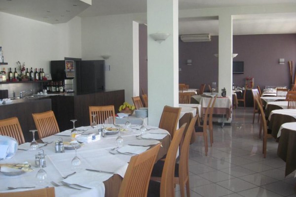 Restauracja z drewnianymi krzesłami i nakrytymi stołami.