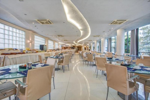 Elegancka restauracja z nowoczesnym wystrojem i szklanymi stołami.