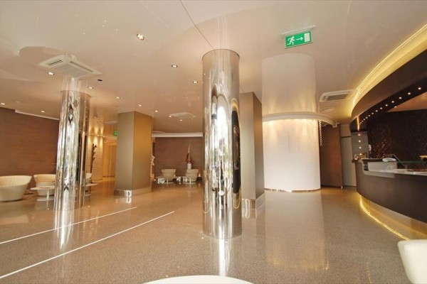 Nowoczesna recepcja hotelowa z lśniącymi kolumnami i wygodnymi miejscami do siedzenia.