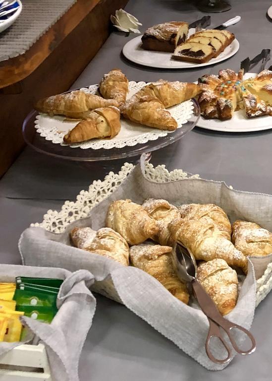 Różne pieczywo w tym croissanty i ciasta na stole.