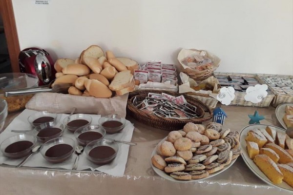 Stół deserowy z pieczywem, ciasteczkami i budyniem czekoladowym.  