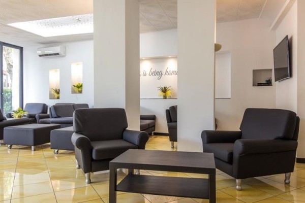 Nowoczesne lobby hotelowe z czarnymi fotelami i stołem.