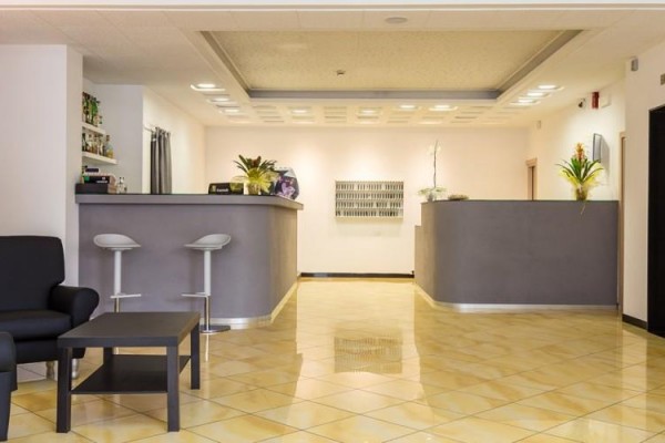 Nowoczesna recepcja hotelowa z miejscem do siedzenia i dekoracjami kwiatowymi.