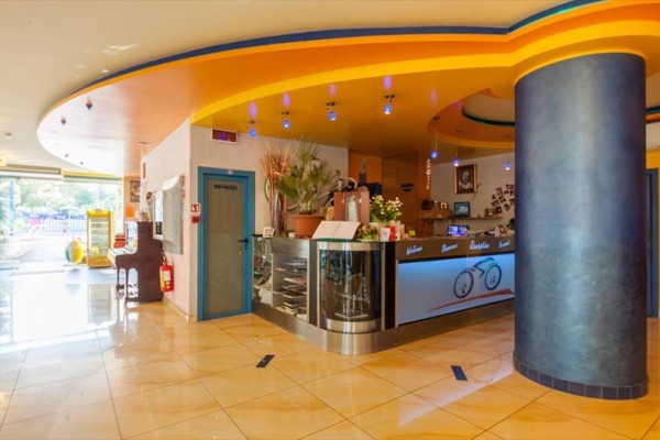 Recepcja hotelu z kolorowym sufitem i nowoczesnym designem.