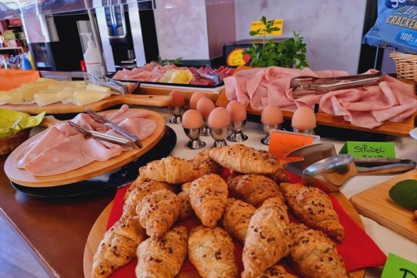 Bufet z świeżym pieczywem, wędlinami, serami i gotowanymi jajkami.