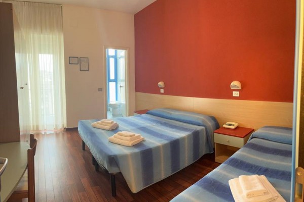 Pokój hotelowy z dwoma łóżkami, telefonem i łazienką.