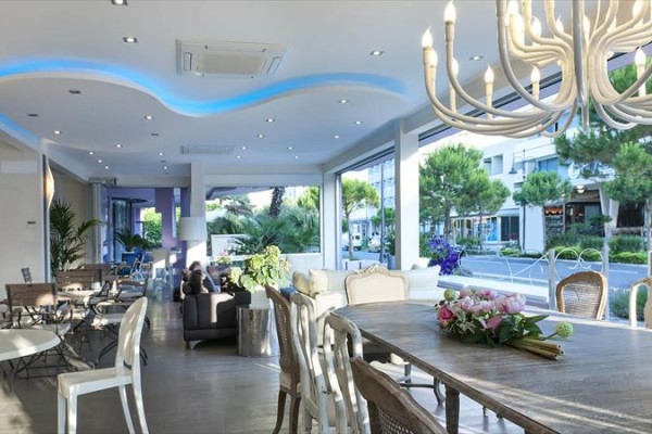 Nowoczesne wnętrze restauracji z dużymi oknami i oświetleniem sufitowym.