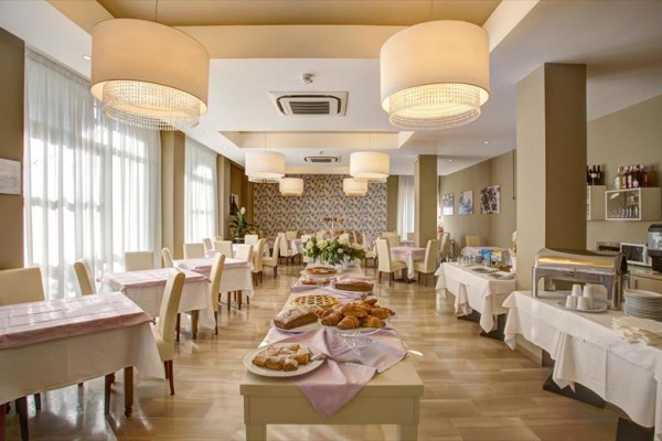 Elegancka restauracja z nakrytymi stołami i bufetem.