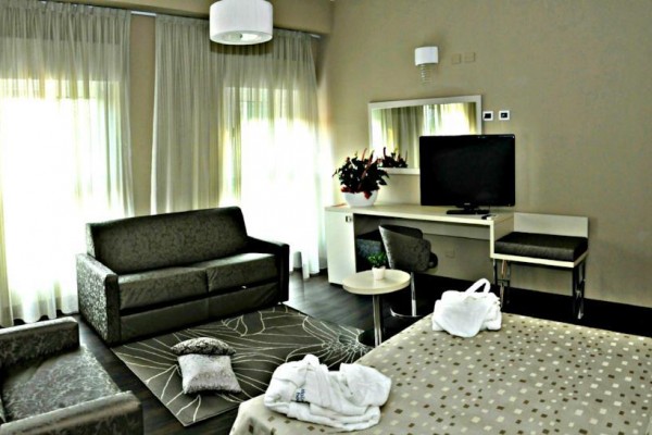 Nowoczesny pokój hotelowy z sofą, telewizorem i biurkiem.