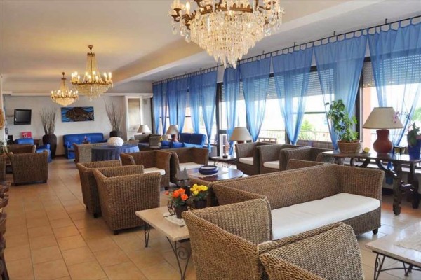 Elegancki salon z rattanowymi meblami i niebieskimi zasłonami.