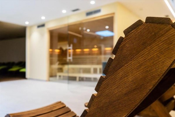 Drewniane leżak w przestrzeni przed przeszkloną sauną.