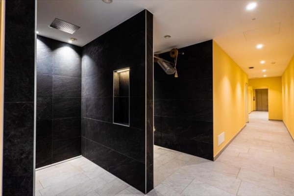 Nowoczesne wnętrze z czarnymi płytkami i żółtymi ścianami.