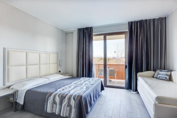 Nowoczesna sypialnia z łóżkiem małżeńskim i balkonem.