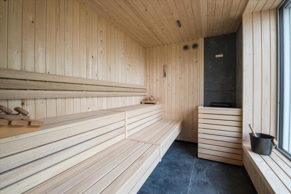 Drewniana sauna z ławami i piecem.