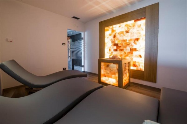 Pokój relaksacyjny z dwoma leżakami i podświetloną ścianą solną.