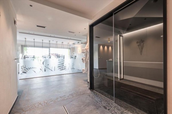 Nowoczesne wnętrze z przeszklonymi drzwiami i dekorowaną ścianą ze szkła.