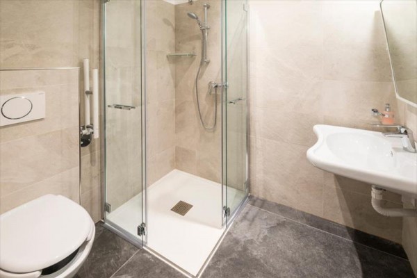 Nowocześnie urządzona łazienka z toaletą, umywalką i prysznicem.