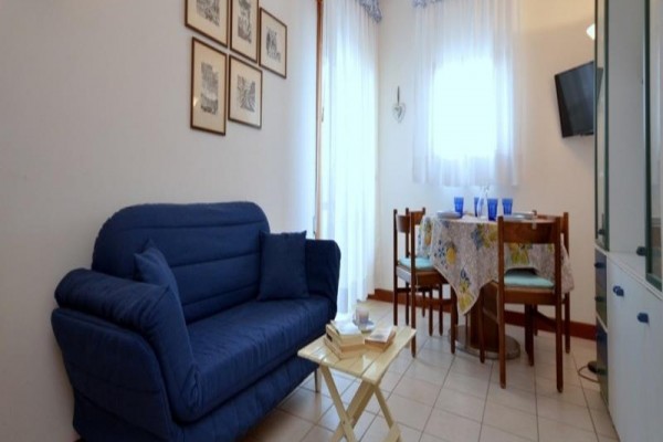 Niebieska sofa w salonie z jadalnym stołem.