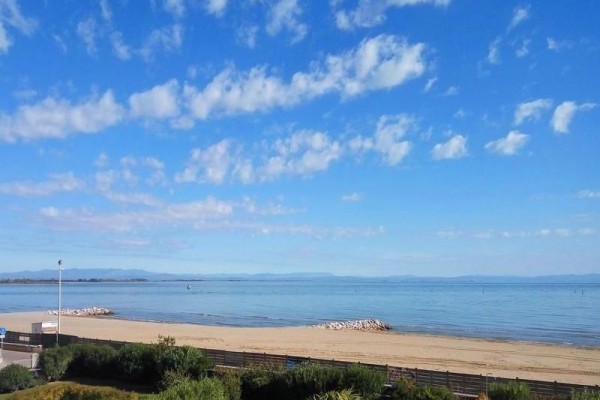 Plaża z widokiem na spokojne morze i niebieskie niebo.