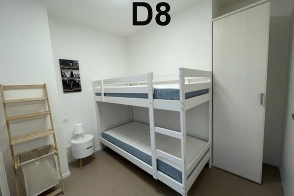 Zielony taras z plastikowym stołem i krzesłami, połączony z kuchnią.